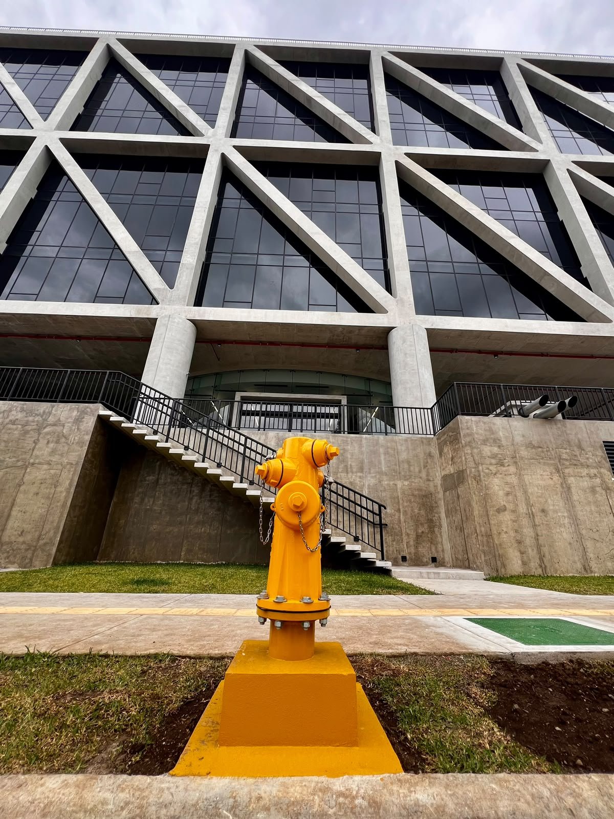Yellow hydrant installed in front of a building facade