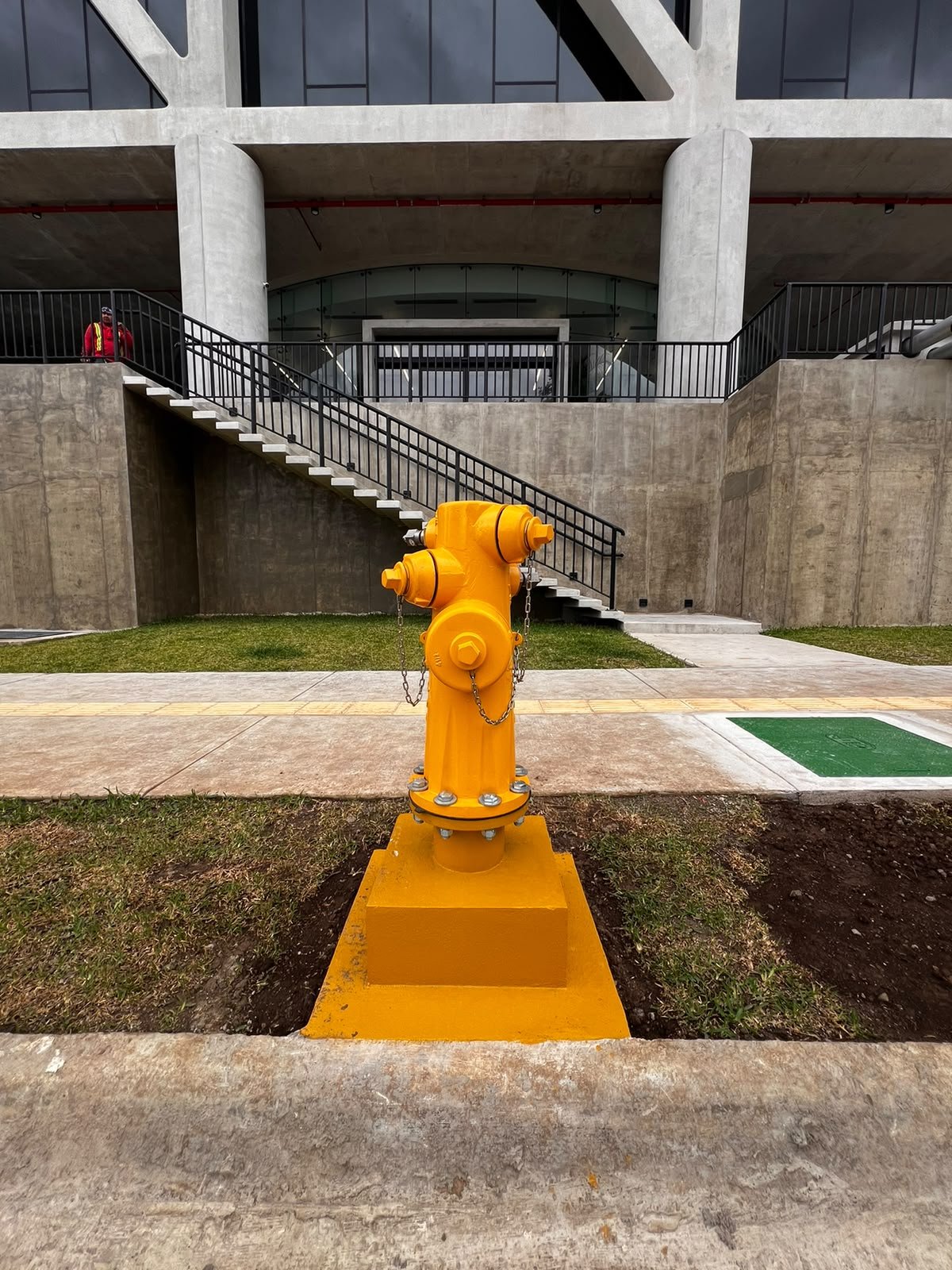 Close-up view of a yellow hydrant installed beside a sidewalk